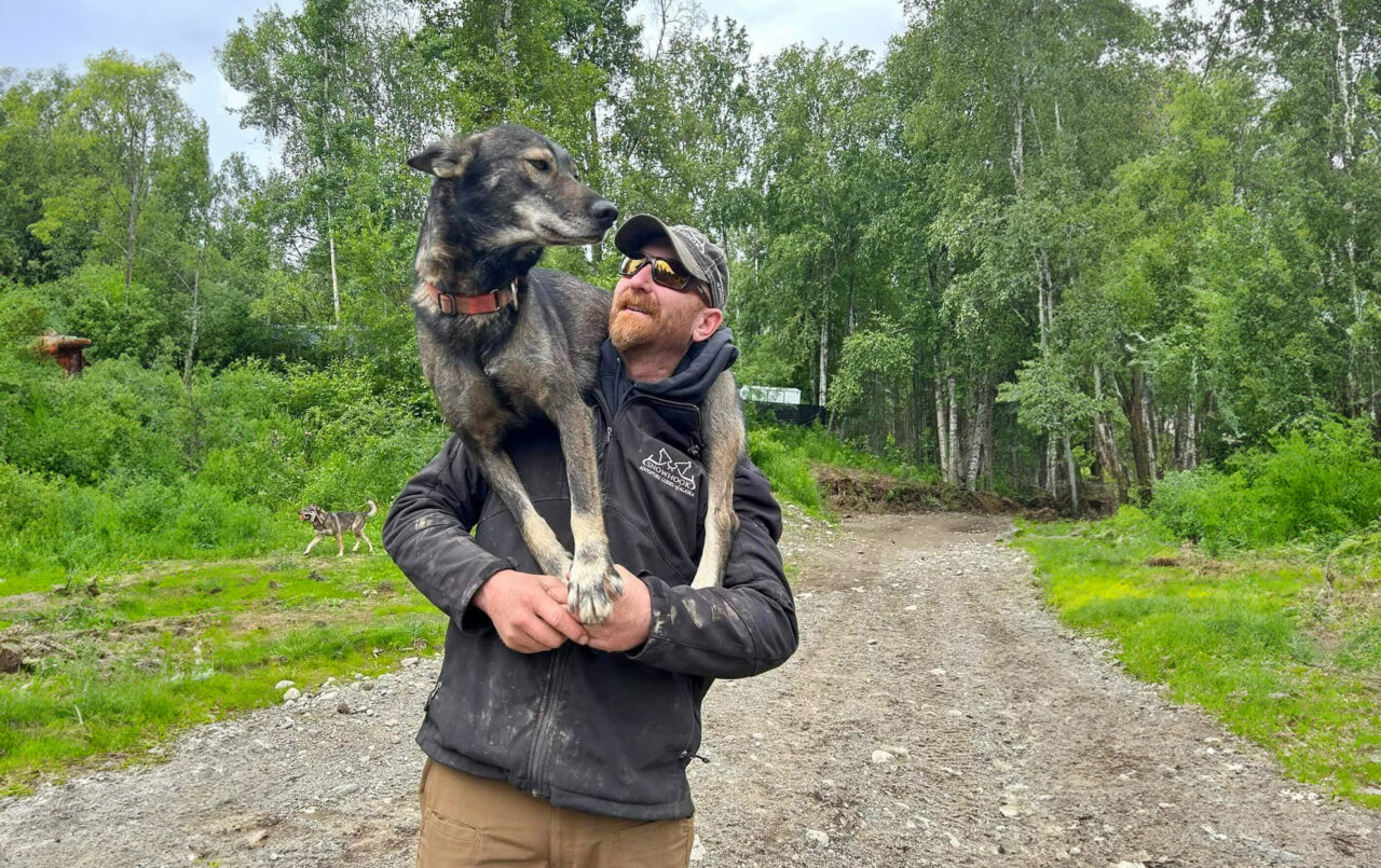 Snowhook Dog Sledding - AJ with Dog on shoulders